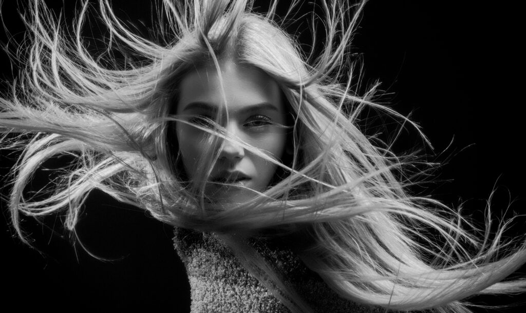 pexels-photo-1027092-1027092 Captivating black and white portrait of a woman with flowing hair, artistic and stylish.